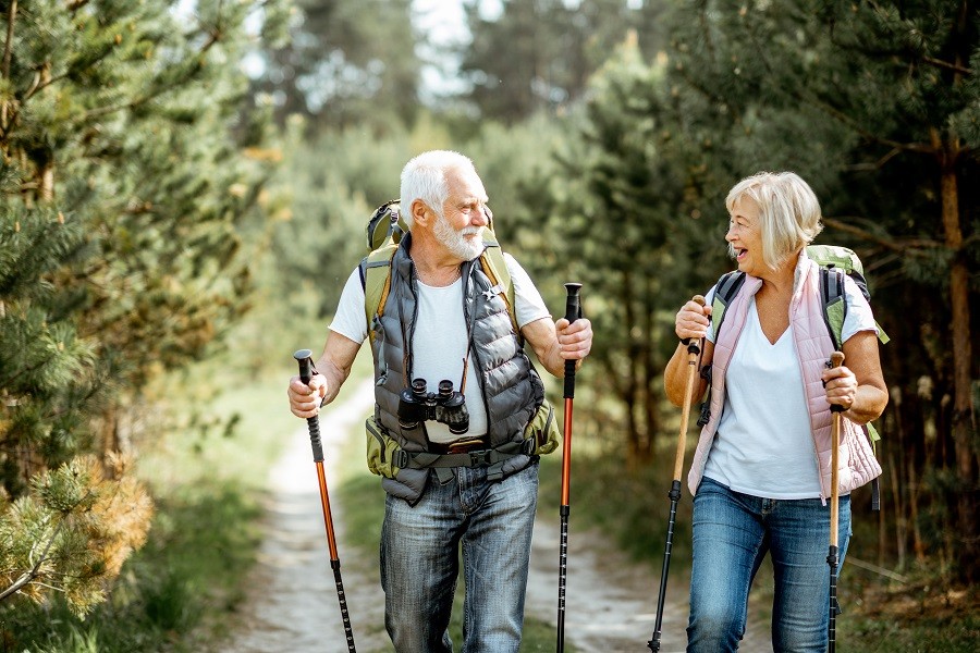 Senior woman and man hiking on a wooded trail