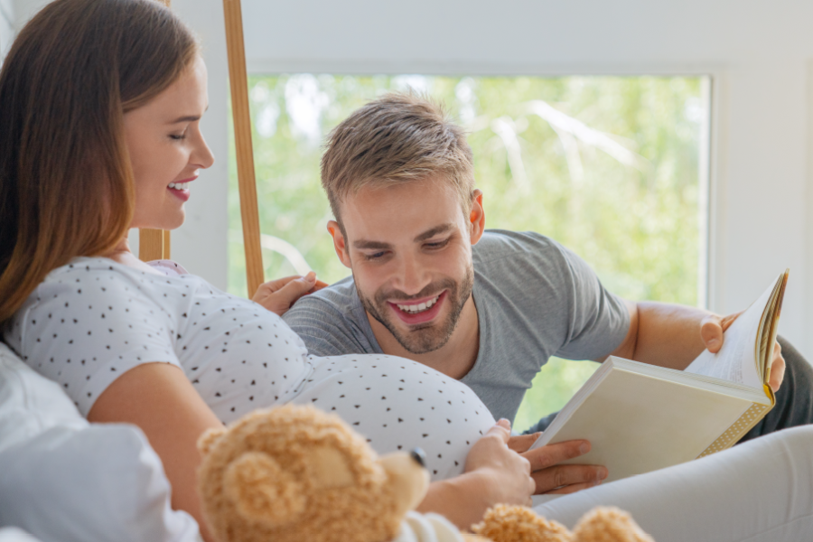 Man reading to his pregnant wife's stomach